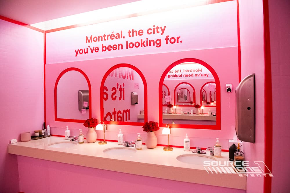Pink experiential display wall featuring branded messaging and arch-shaped graphics.